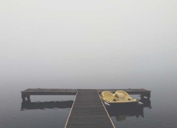 A Paddle Boat Anchored to a Wooden Dock