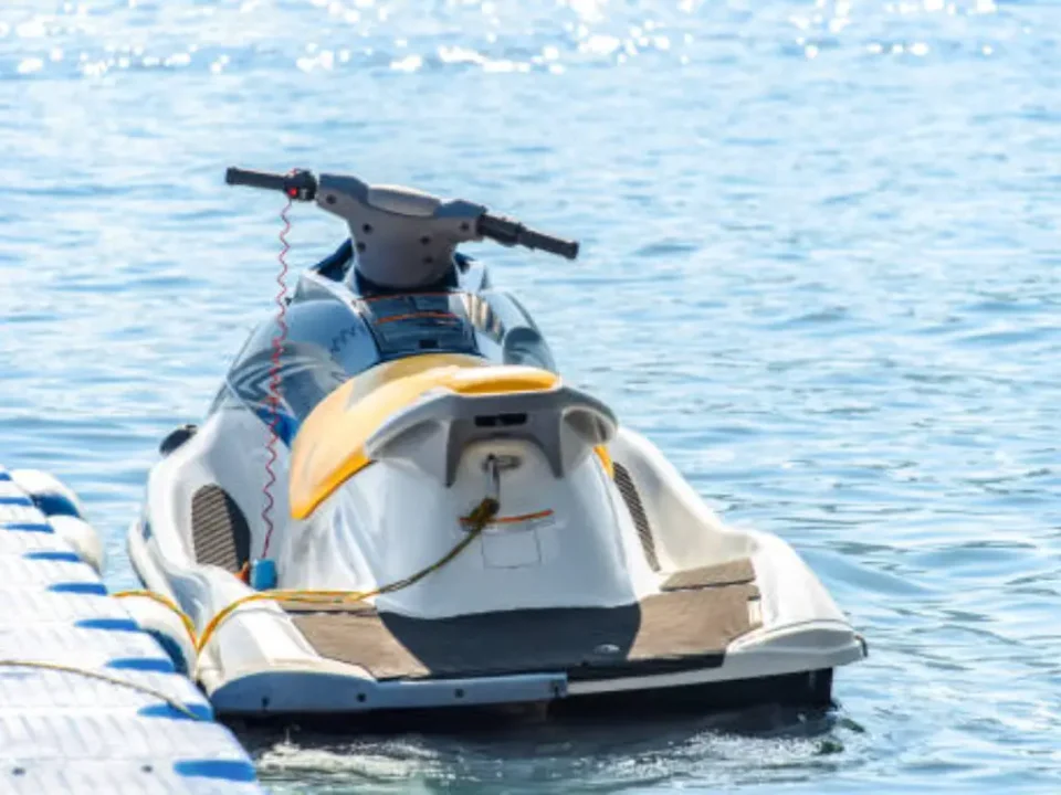 Jetski, der mit einem Seil an einem modularen schwimmenden Kunststoffponton befestigt ist
