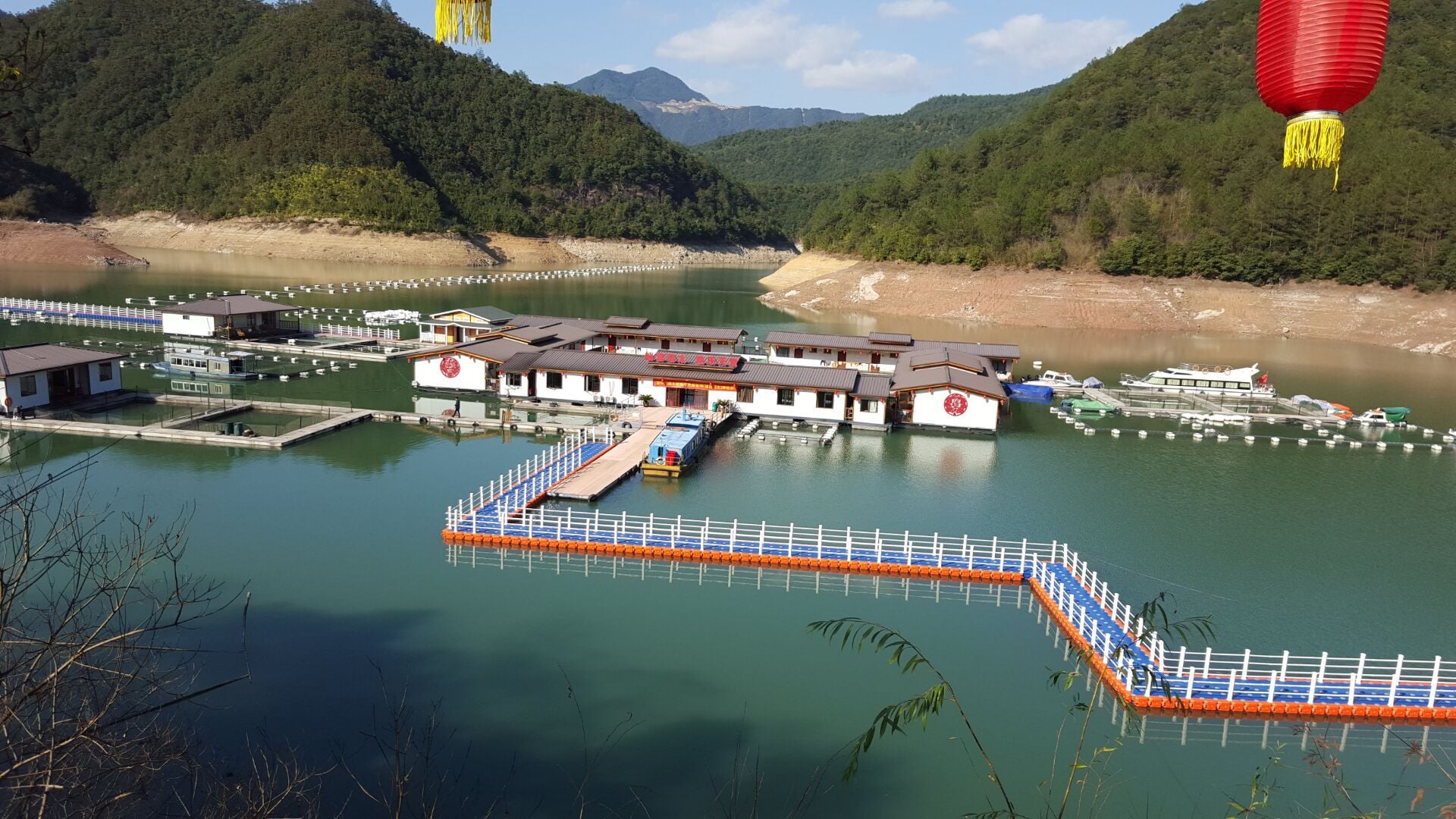 Blaue und orangefarbene modulare Schwimmbrücke, die schwimmende Anlagen in Ufernähe miteinander verbindet