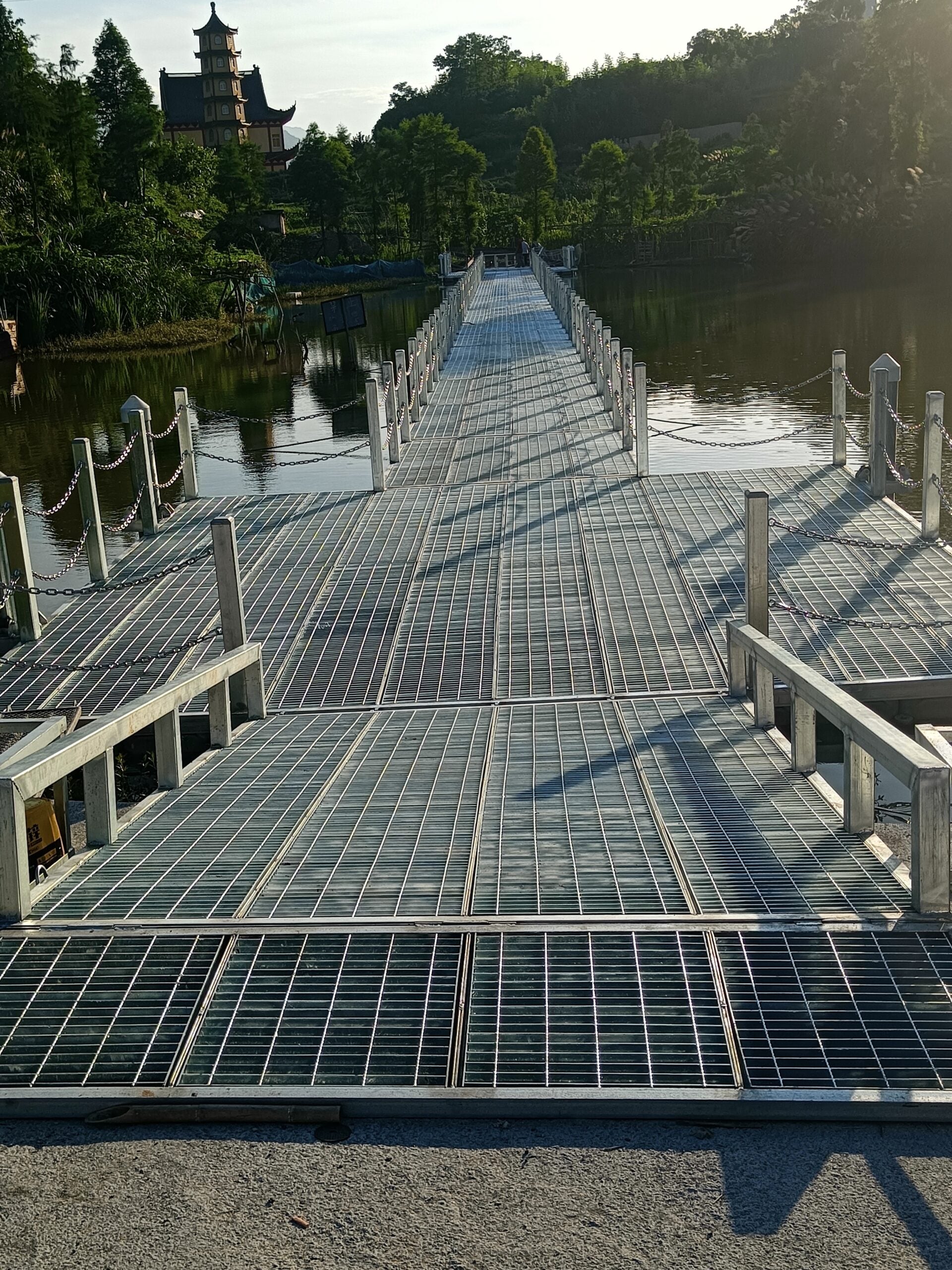 Metal-grating waterfront walkway with posts and chains