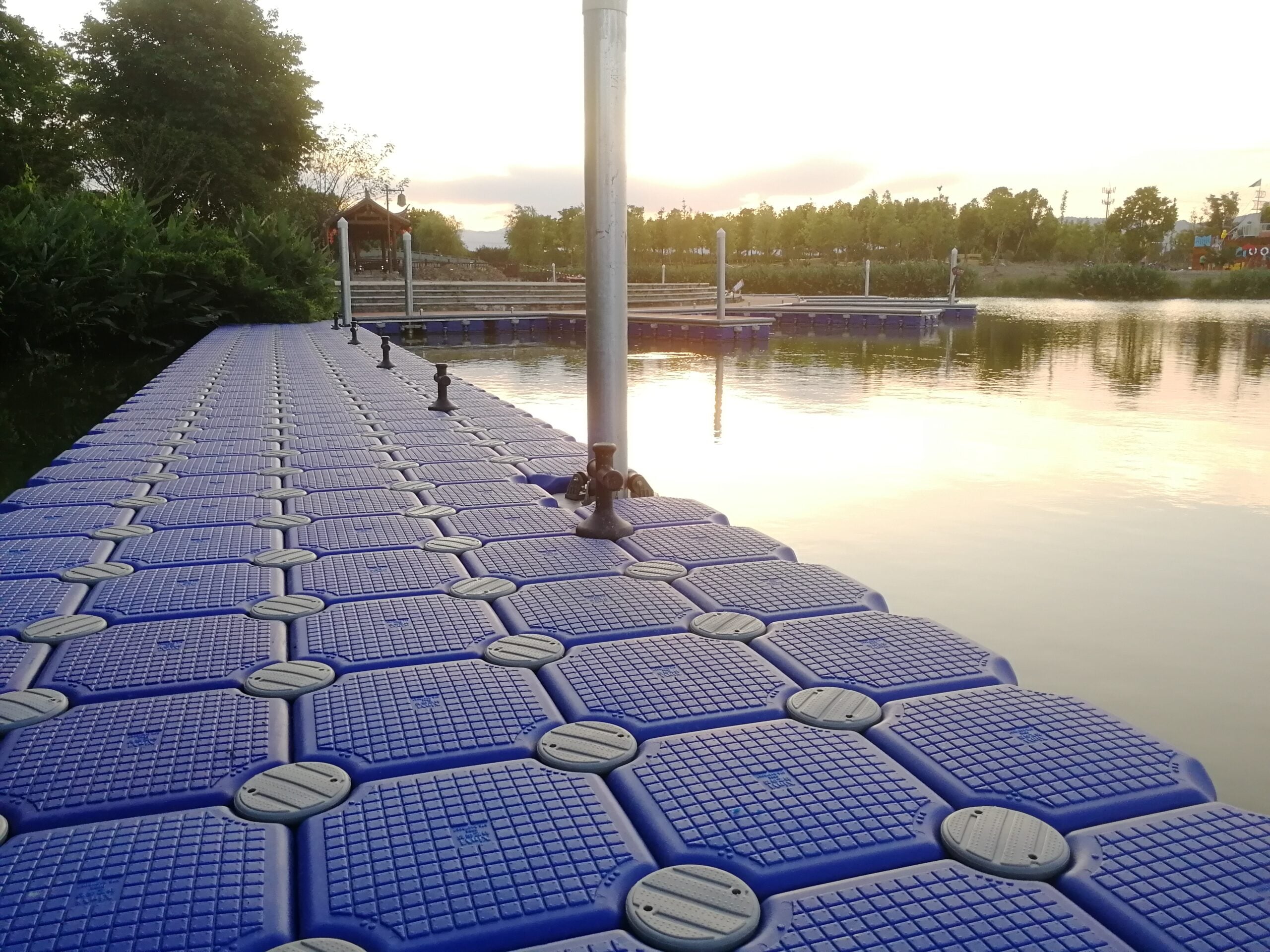 Blue dock modules with round connection heads and an adjacent pile