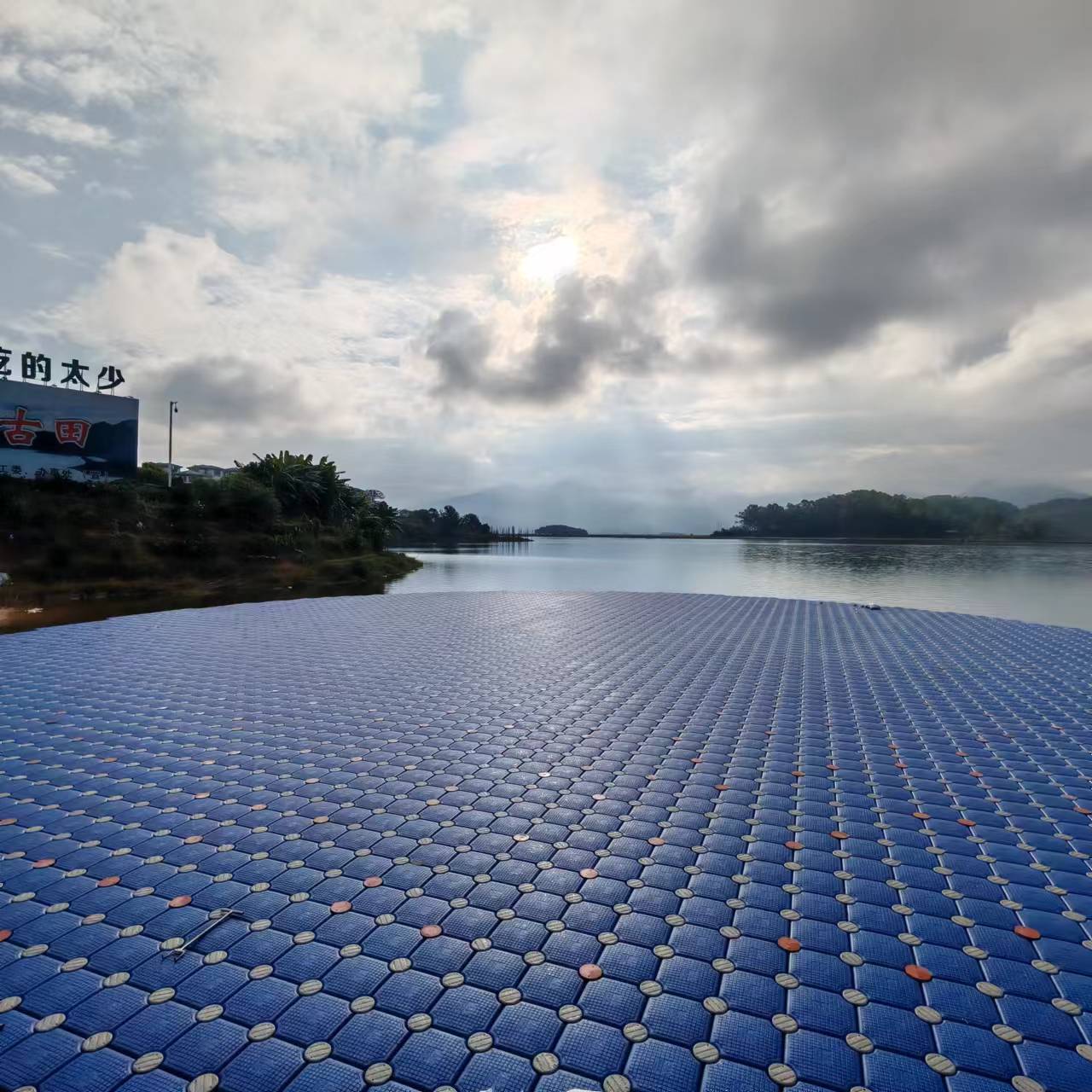 Large blue modular floating platform on open water